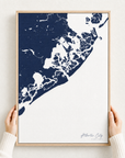 Atlantic City canvas map — hands holding the canvas in an oak frame