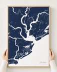Charleston canvas map — hands holding the canvas in an oak frame