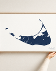 Nantucket horizontal canvas map in Navy, hands holding an oak-framed canvas