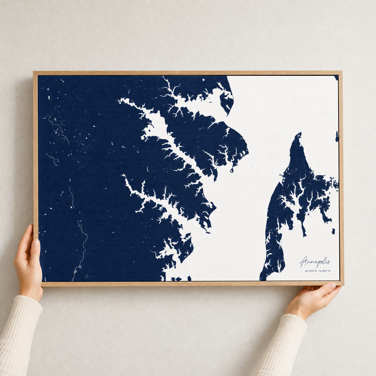 Annapolis canvas map — hands holding the canvas in an oak frame