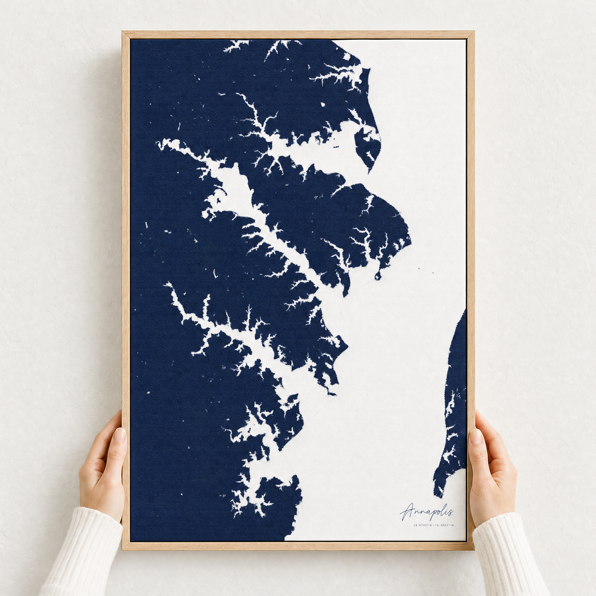 Annapolis canvas map — hands holding the canvas in an oak frame
