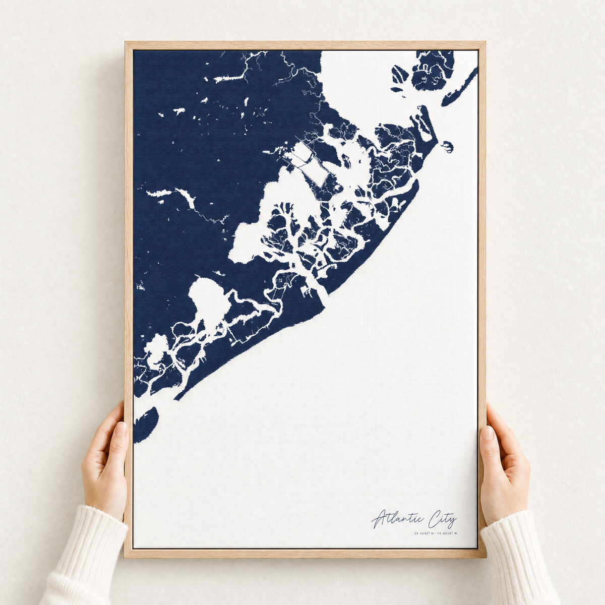 Atlantic City canvas map — hands holding the canvas in an oak frame