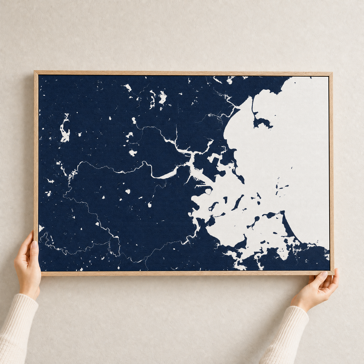Boston canvas map — hands holding the canvas in an oak frame