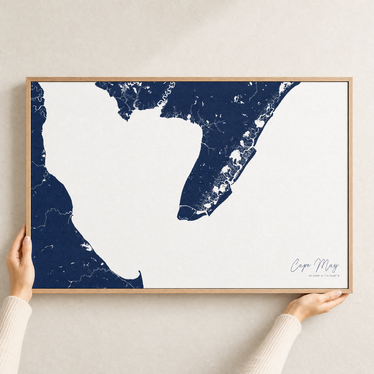 Cape May canvas map — hands holding the canvas in an oak frame