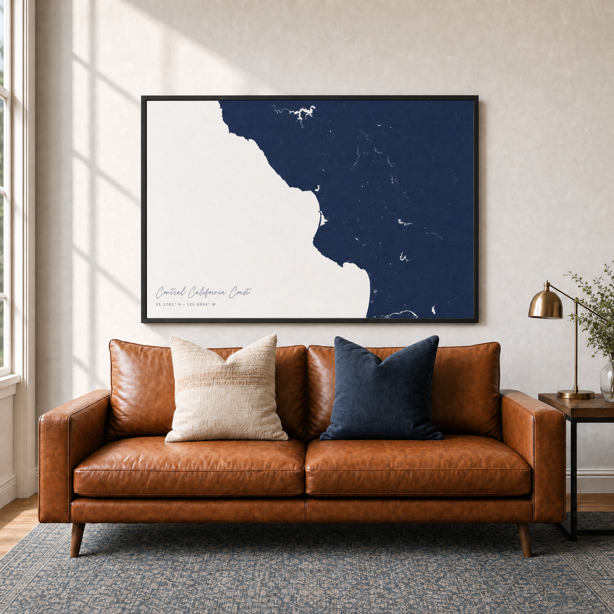 Central California Coast canvas map — two-pillow black-frame sofa interior