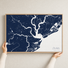 Charleston canvas map — hands holding the canvas in an oak frame