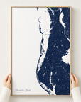 Clearwater Beach canvas map — hands holding the canvas in an oak frame