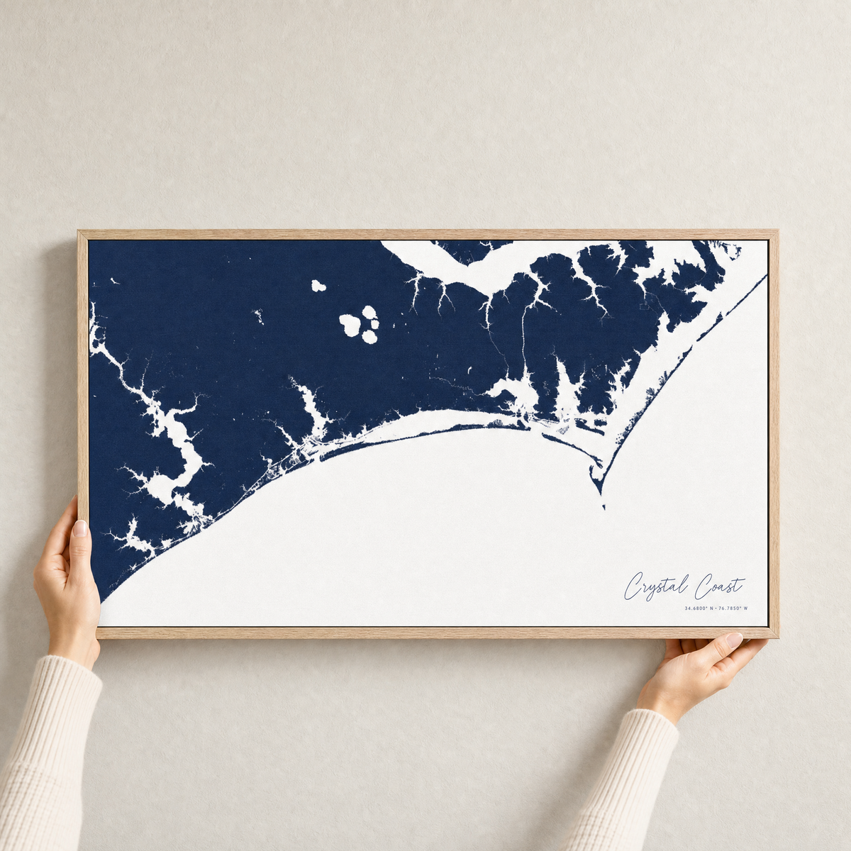 Crystal Coast / Emerald Isle canvas map — hands holding the canvas in an oak frame