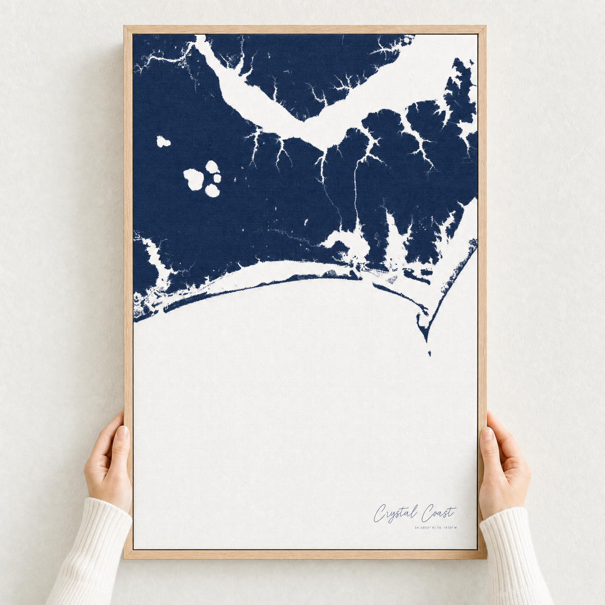 Crystal Coast / Emerald Isle canvas map — hands holding the canvas in an oak frame