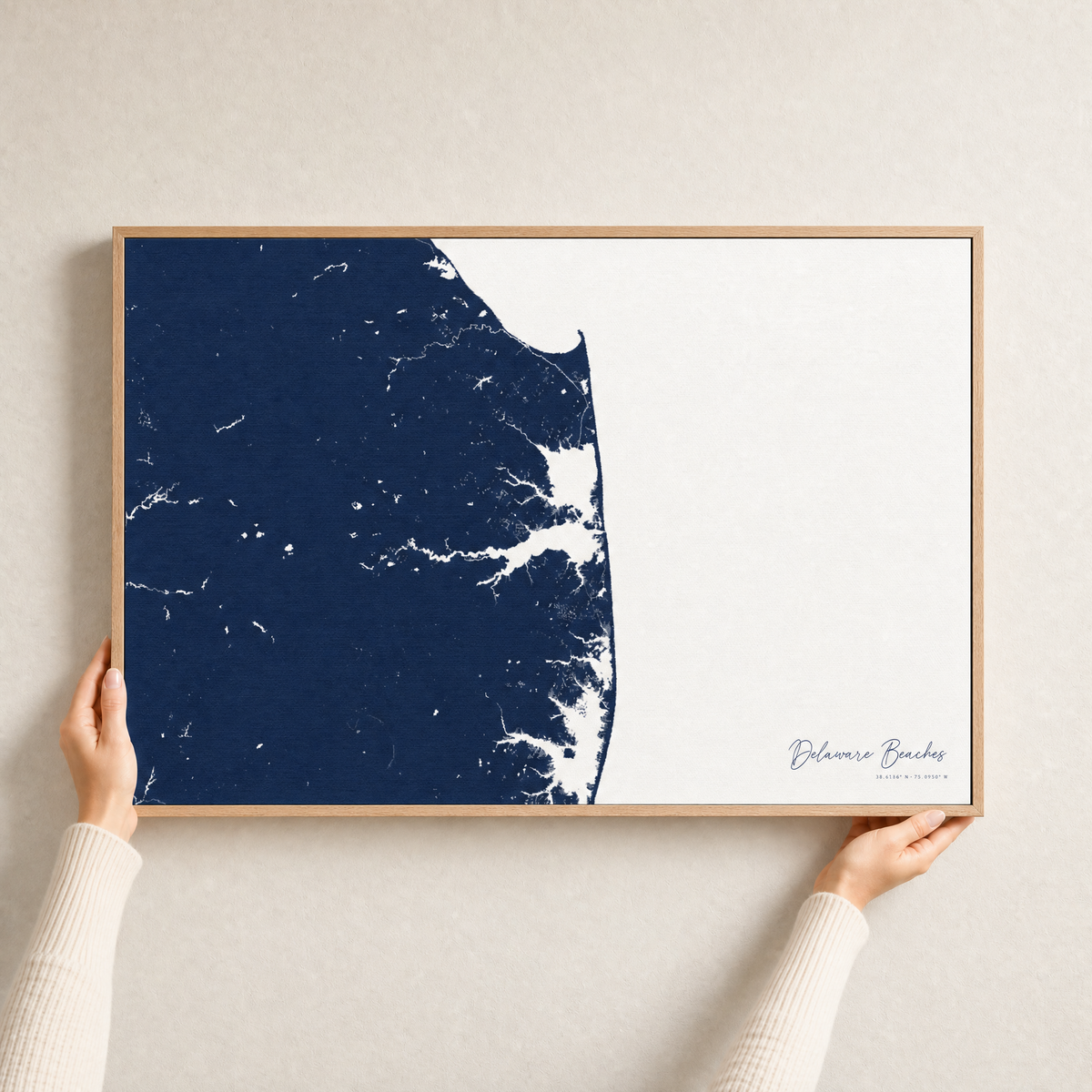 Delaware Beaches canvas map — hands holding the canvas in an oak frame