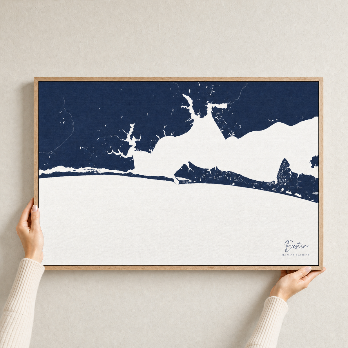 Destin canvas map — hands holding the canvas in an oak frame