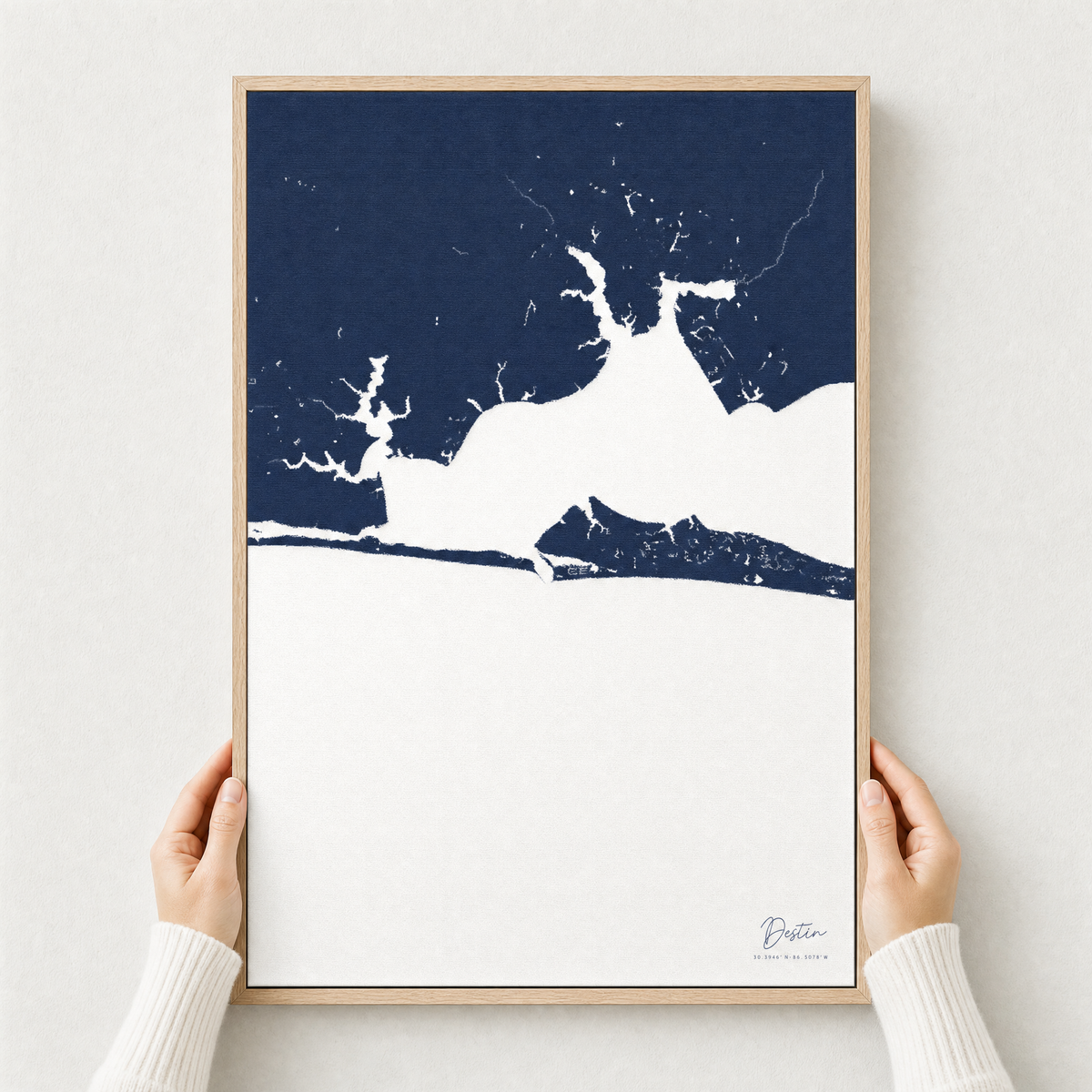 Destin canvas map — hands holding the canvas in an oak frame