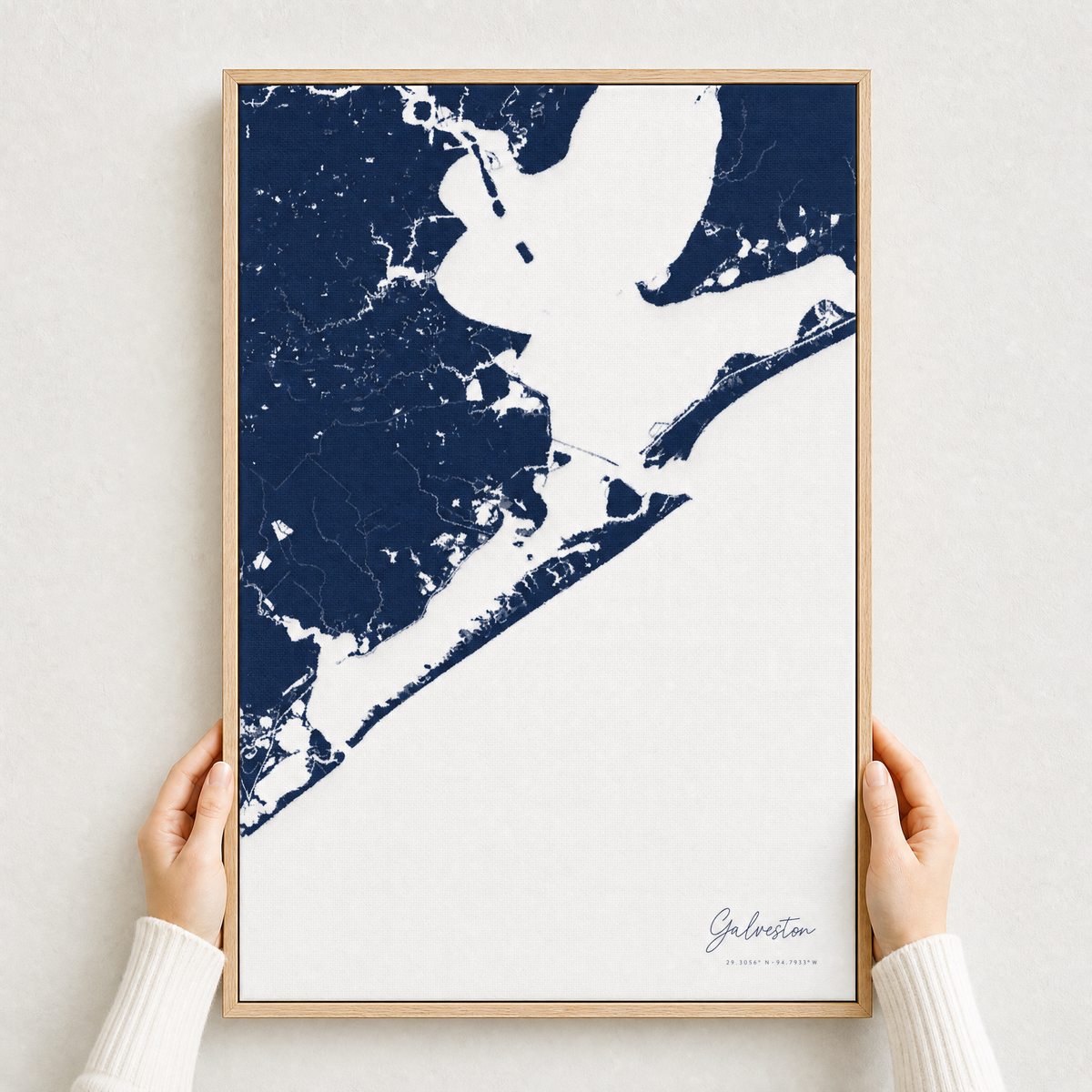 Galveston canvas map — hands holding the canvas in an oak frame