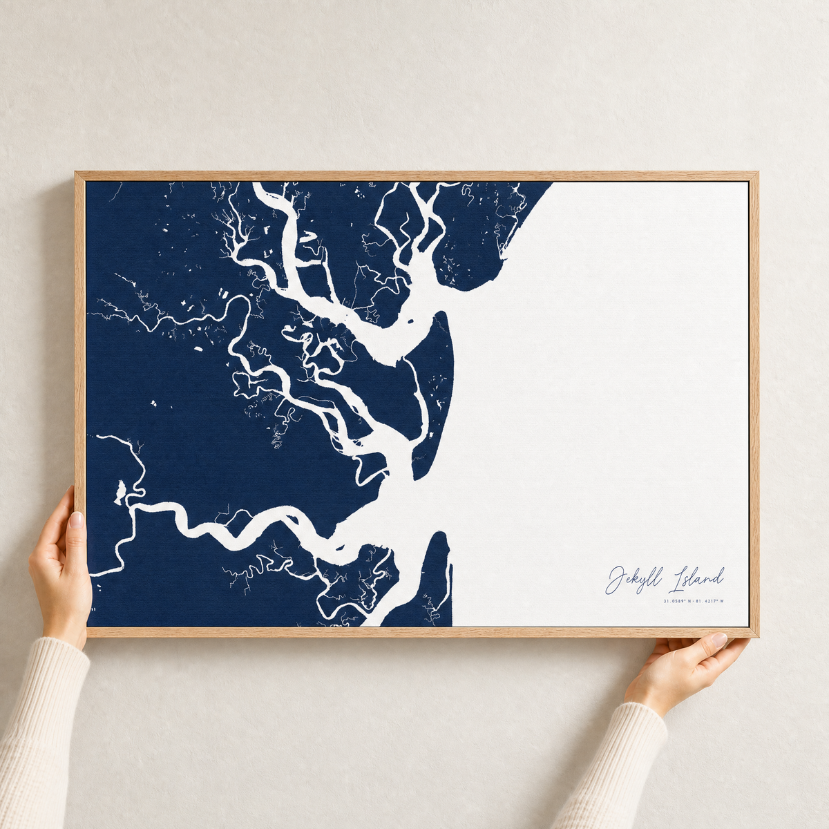 Jekyll Island canvas map — hands holding the canvas in an oak frame