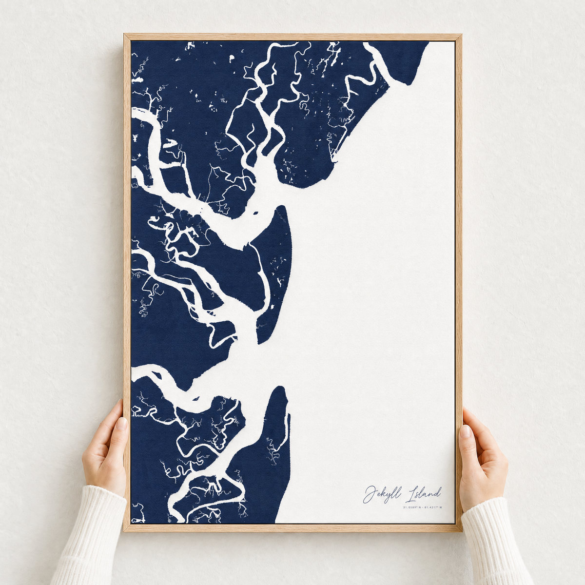 Jekyll Island canvas map — hands holding the canvas in an oak frame