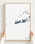 Key West canvas map — hands holding the canvas in an oak frame
