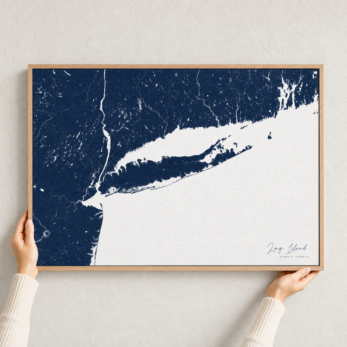 Long Island canvas map — hands holding the canvas in an oak frame