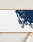 Marco Island canvas map — hands holding the canvas in an oak frame