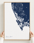 Marco Island canvas map — hands holding the canvas in an oak frame