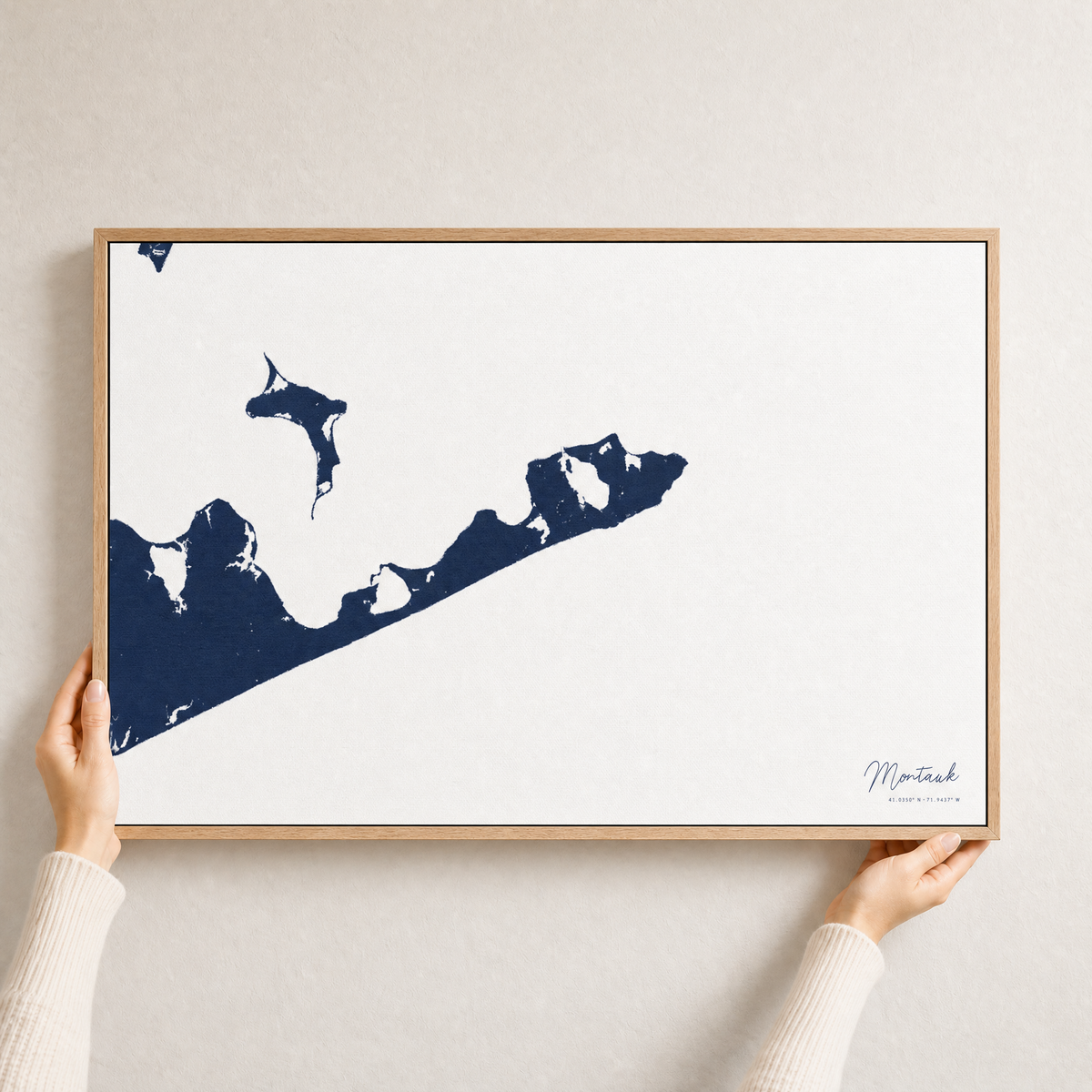 Montauk canvas map — hands holding the canvas in an oak frame