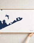 Montauk canvas map — hands holding the canvas in an oak frame