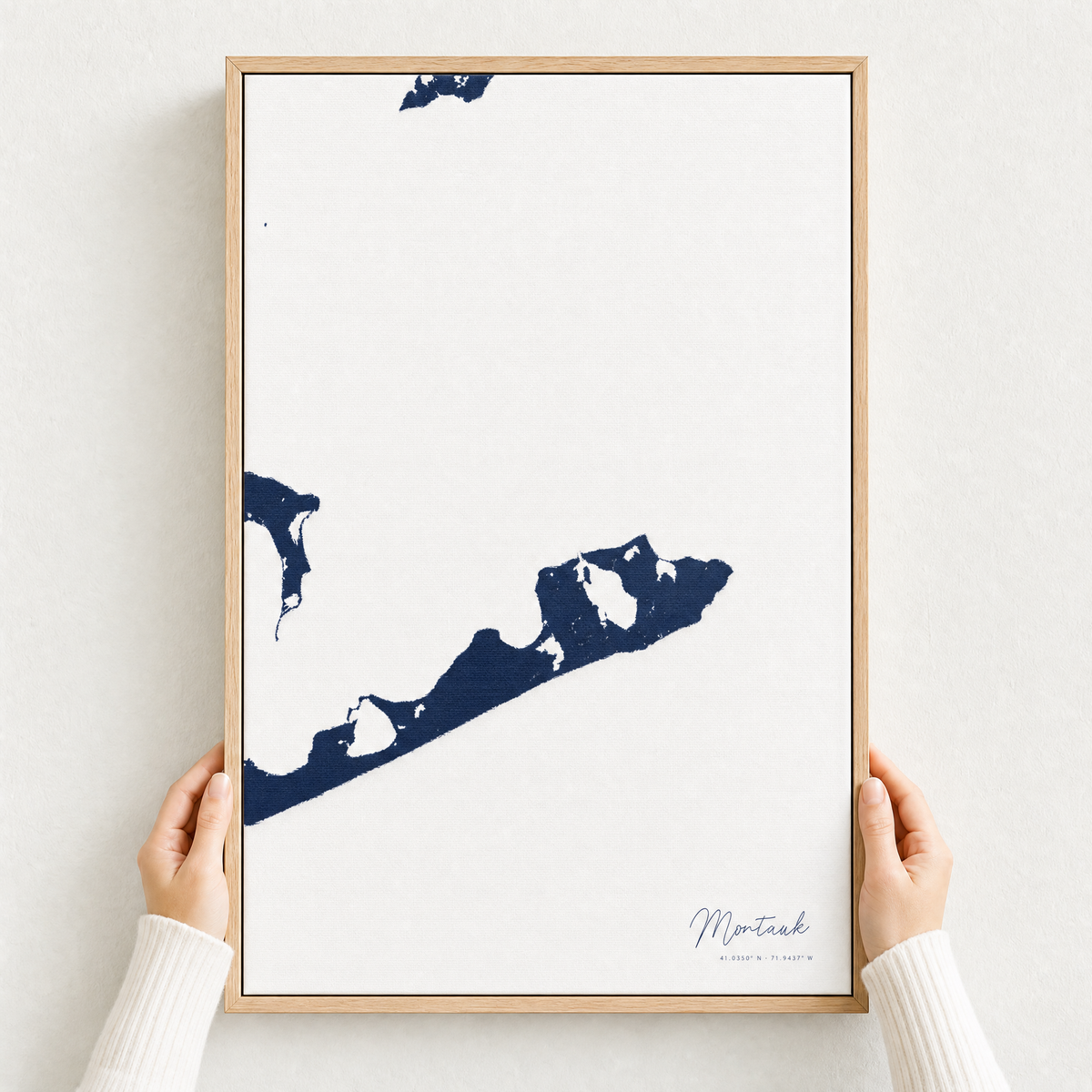 Montauk canvas map — hands holding the canvas in an oak frame
