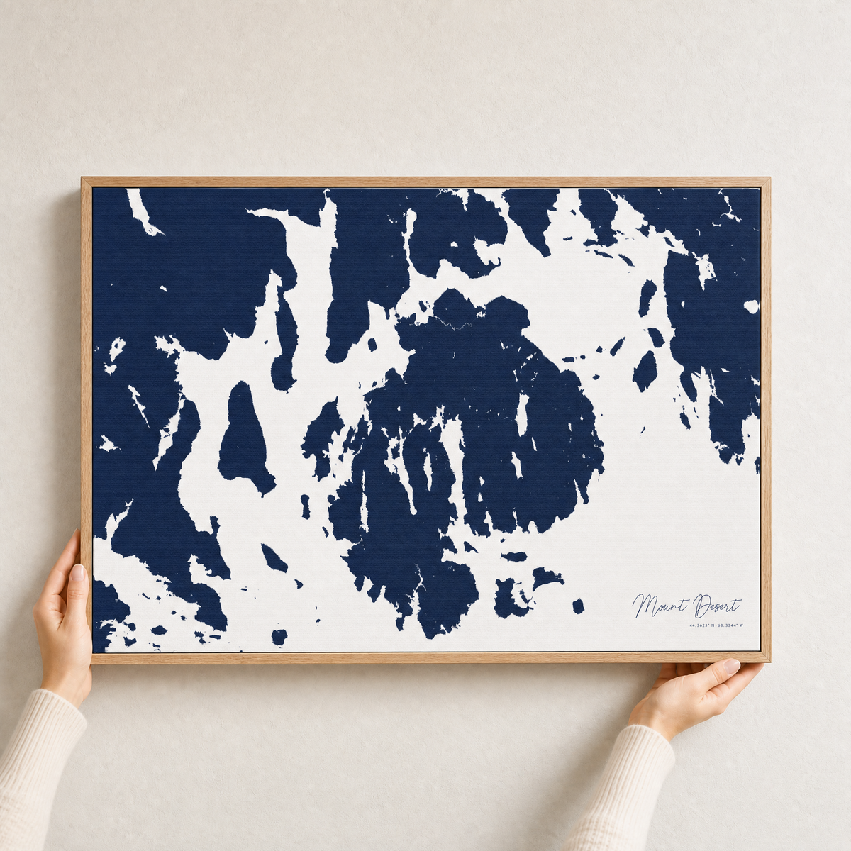 Mount Desert canvas map — hands holding the canvas in an oak frame