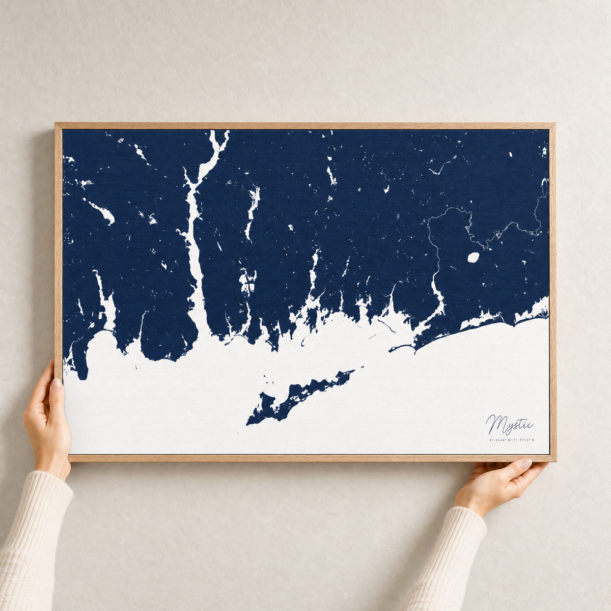 Mystic canvas map — hands holding the canvas in an oak frame