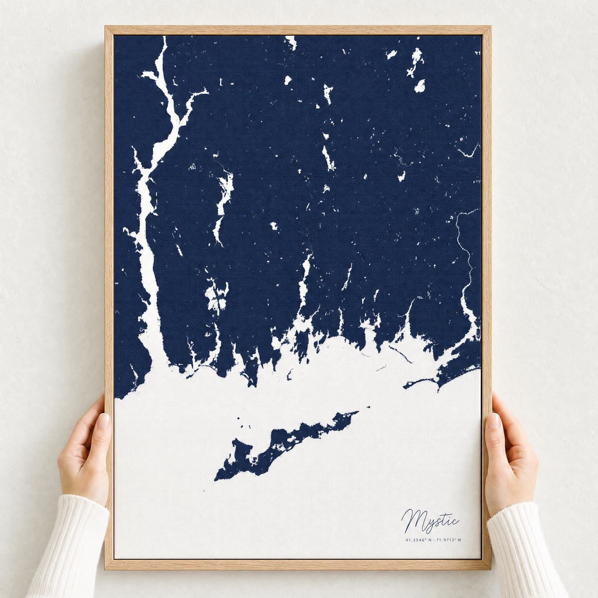Mystic canvas map — hands holding the canvas in an oak frame
