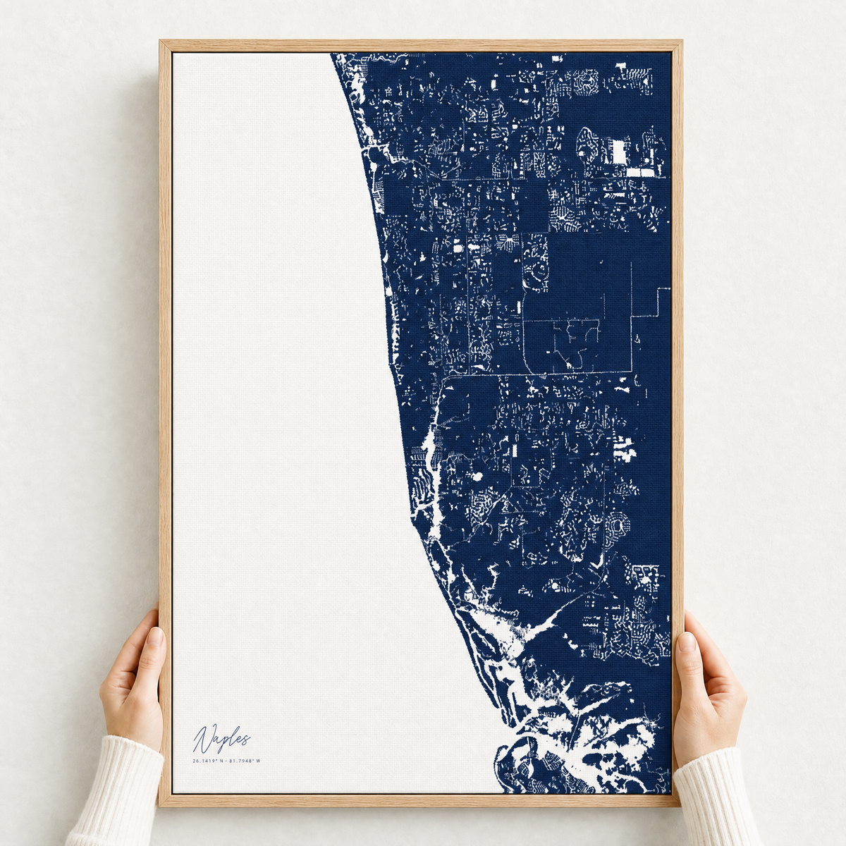 Naples canvas map — hands holding the canvas in an oak frame