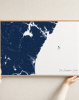 New Hampshire Coast canvas map — hands holding the canvas in an oak frame
