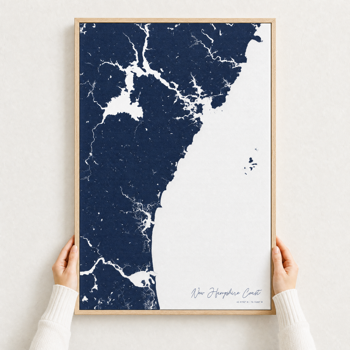 New Hampshire Coast canvas map — hands holding the canvas in an oak frame