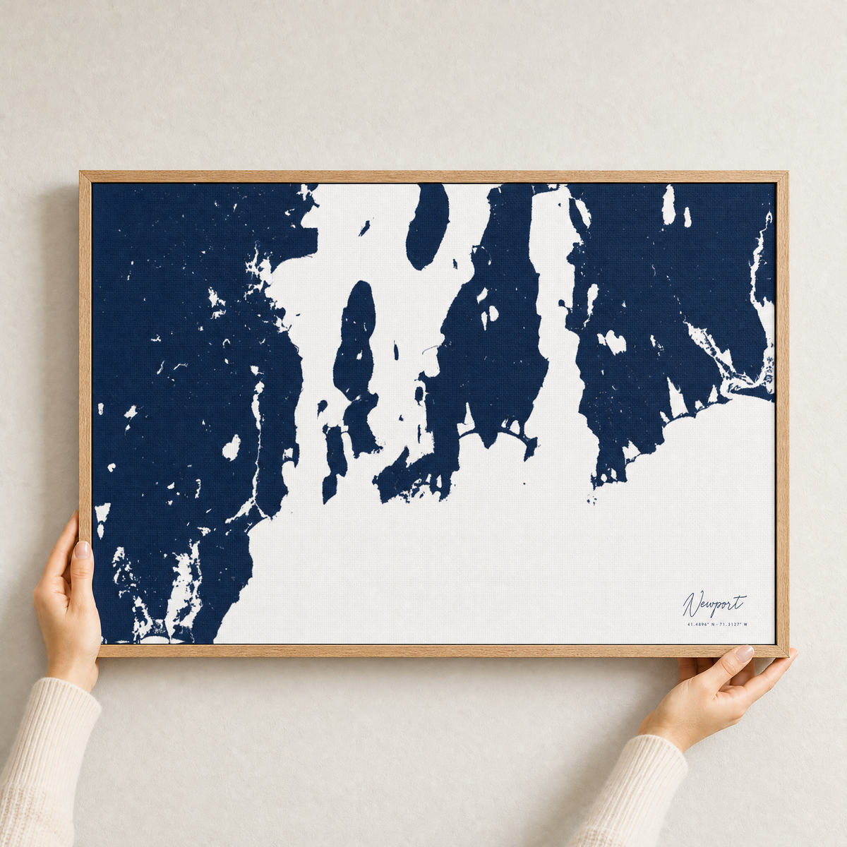 Newport canvas map — hands holding the canvas in an oak frame