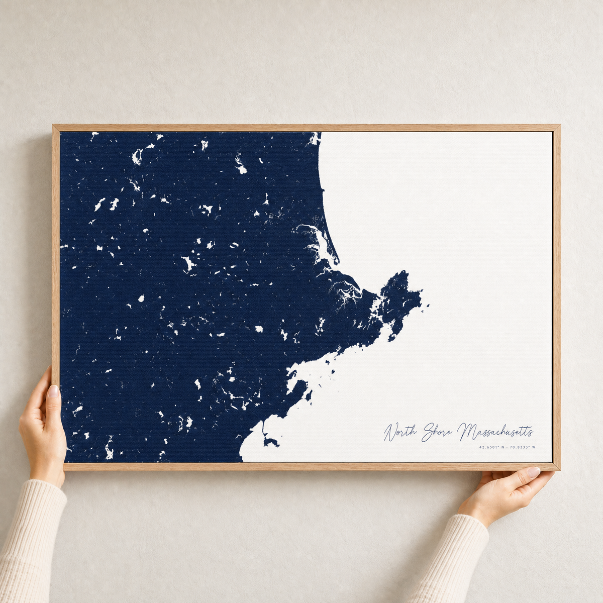 North Shore Massachusetts canvas map — hands holding the canvas in an oak frame