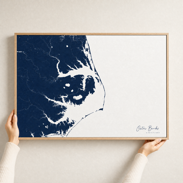 Outer Banks canvas map — hands holding the canvas in an oak frame
