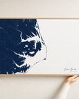 Outer Banks canvas map — hands holding the canvas in an oak frame