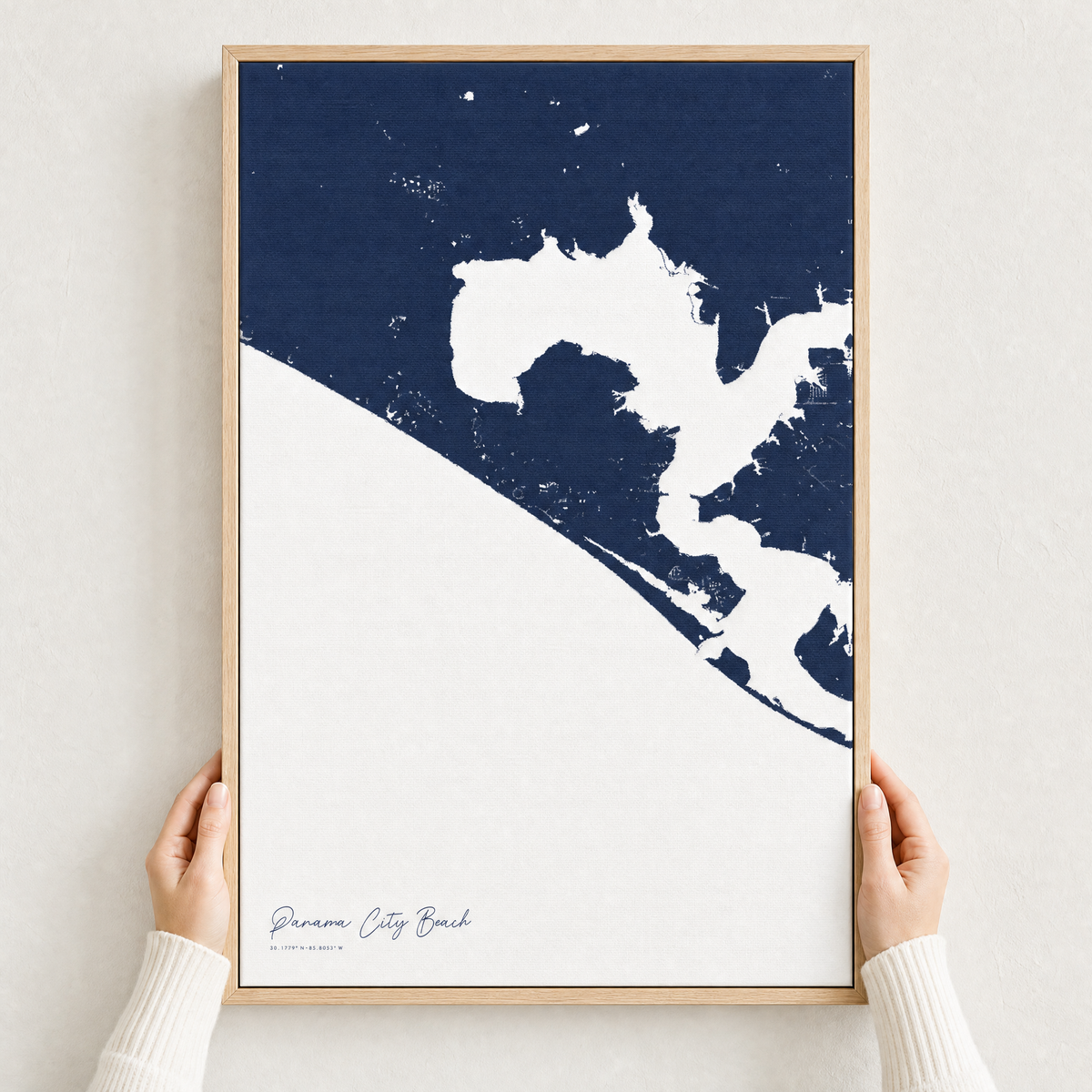 Panama City Beach canvas map — hands holding the canvas in an oak frame