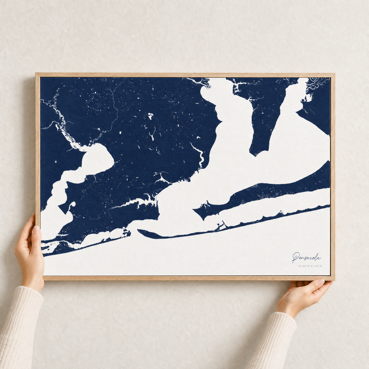 Pensacola canvas map — hands holding the canvas in an oak frame