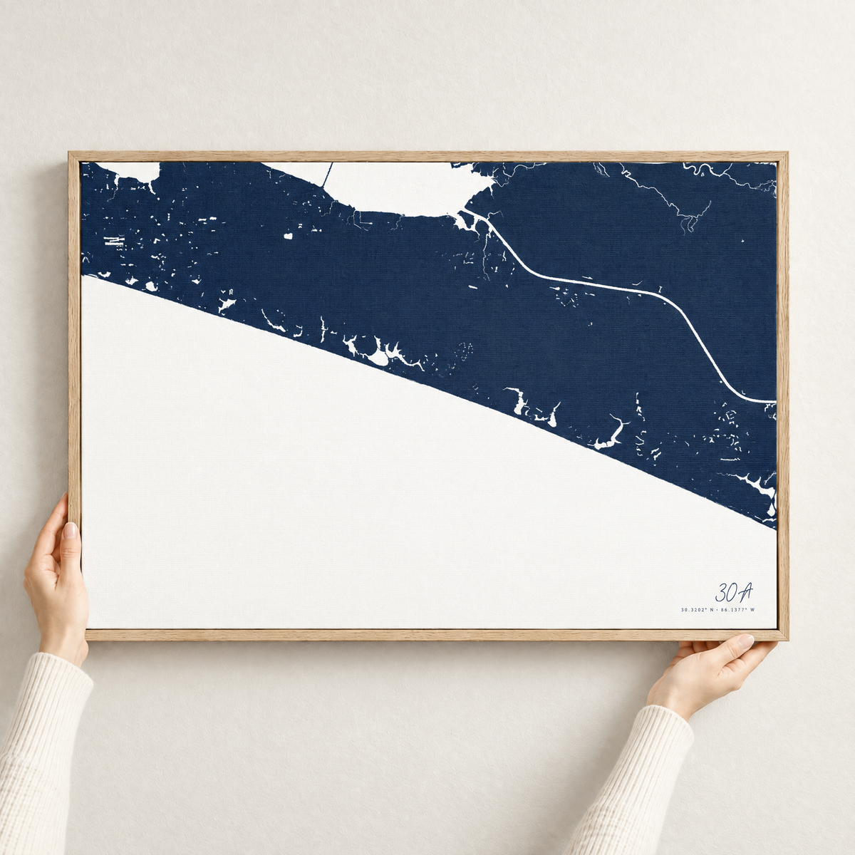 30A horizontal canvas map in Navy, hands holding an oak-framed canvas