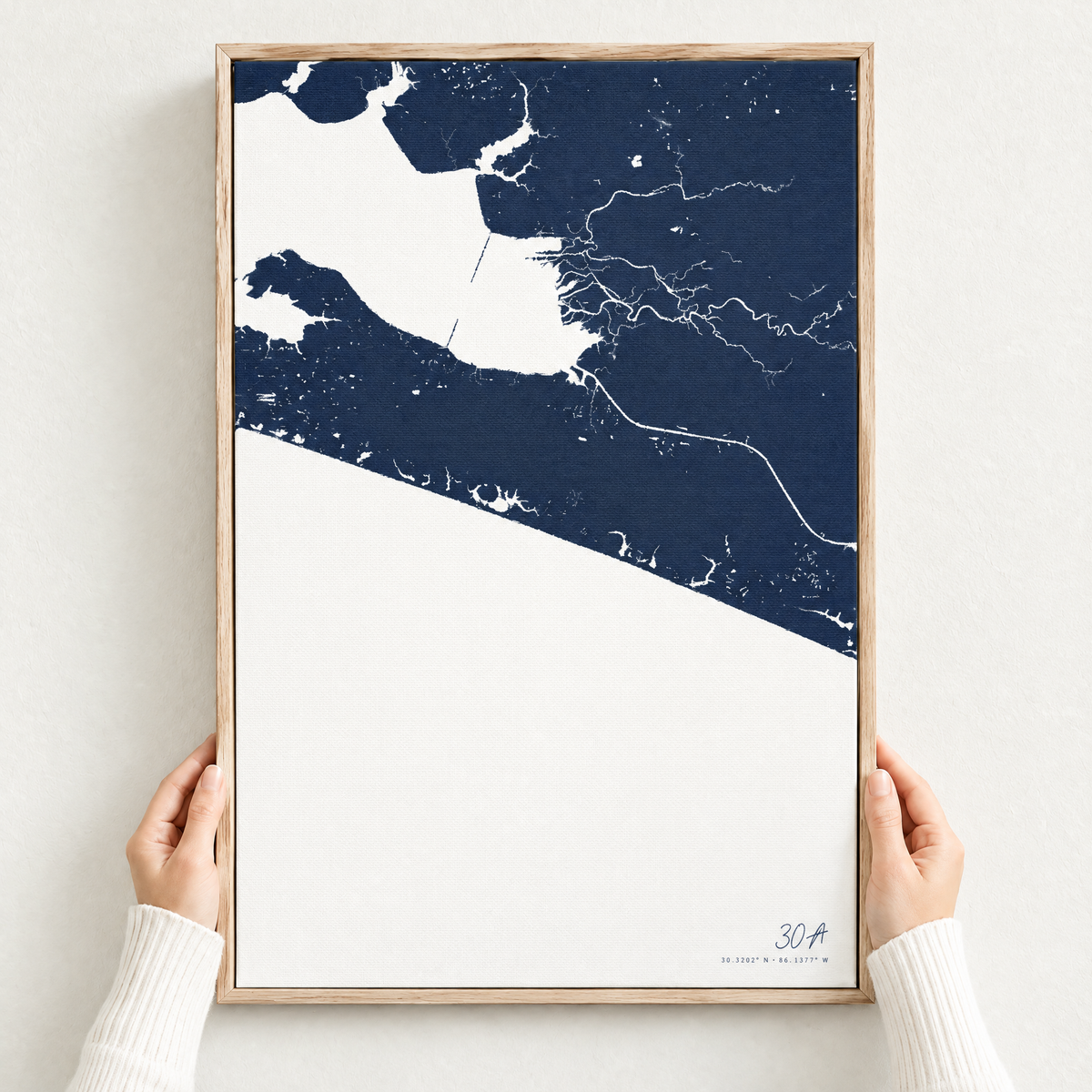 30A vertical canvas map in Navy, hands holding an oak-framed canvas