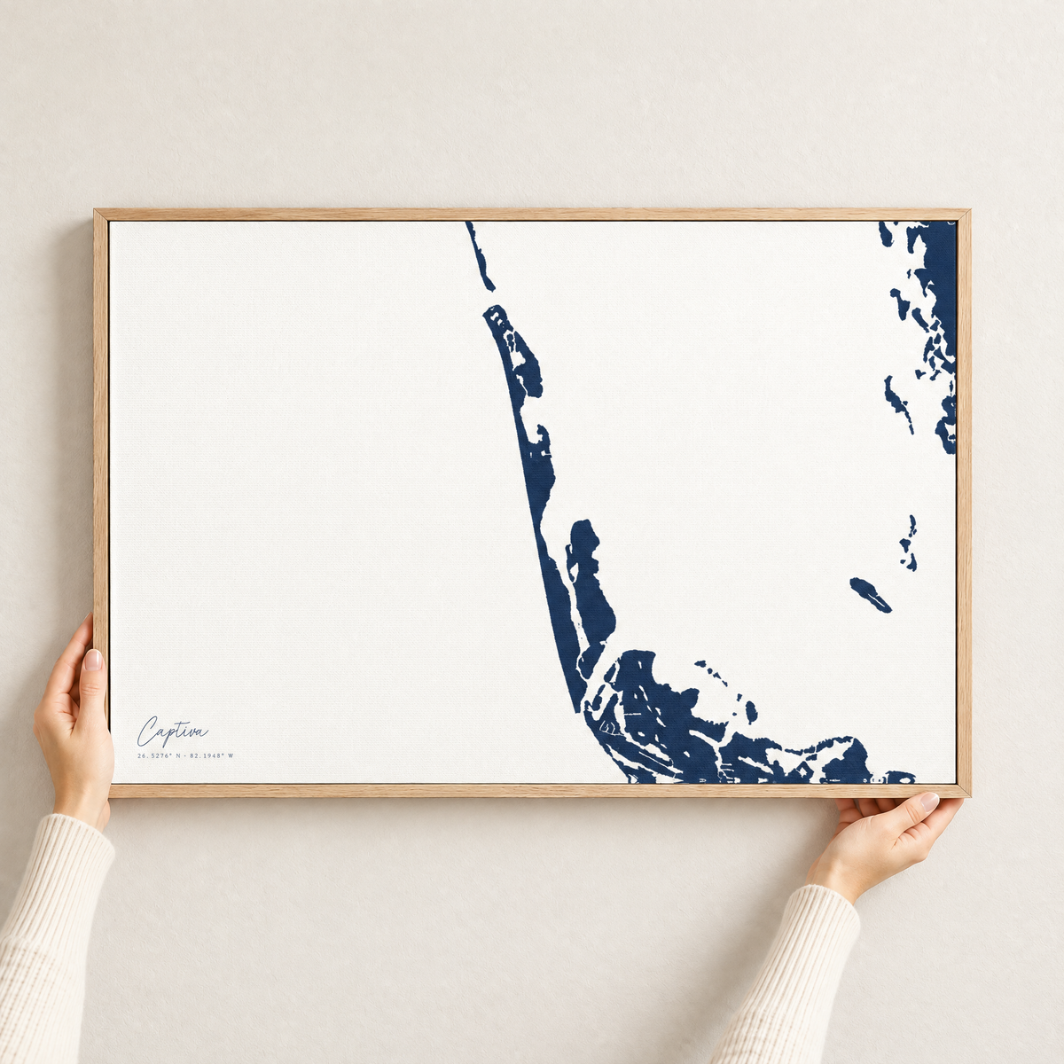 Captiva horizontal canvas map in Navy, hands holding an oak-framed canvas