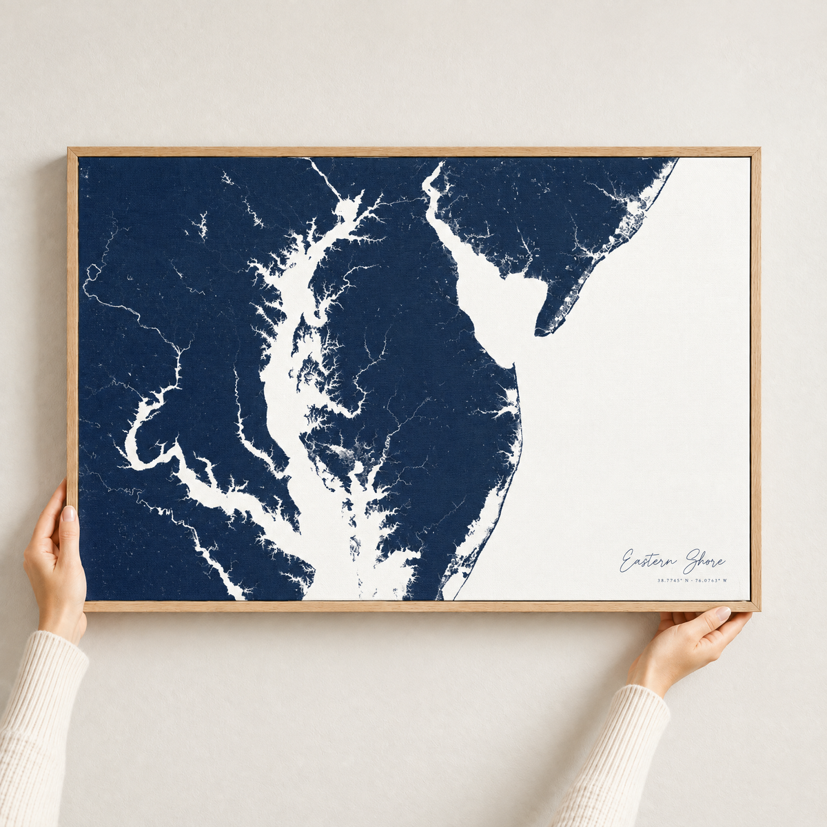Eastern Shore horizontal canvas map in Navy, hands holding an oak-framed canvas