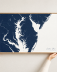 Eastern Shore horizontal canvas map in Navy, hands holding an oak-framed canvas