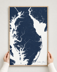 Eastern Shore vertical canvas map in Navy, hands holding an oak-framed canvas