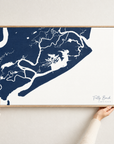 Folly Beach horizontal canvas map in Navy, hands holding an oak-framed canvas