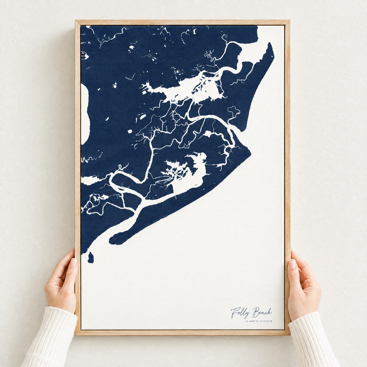 Folly Beach vertical canvas map in Navy, hands holding an oak-framed canvas