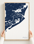 Folly Beach vertical canvas map in Navy, hands holding an oak-framed canvas
