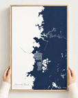 Hernando Beach vertical canvas map in Navy, hands holding an oak-framed canvas