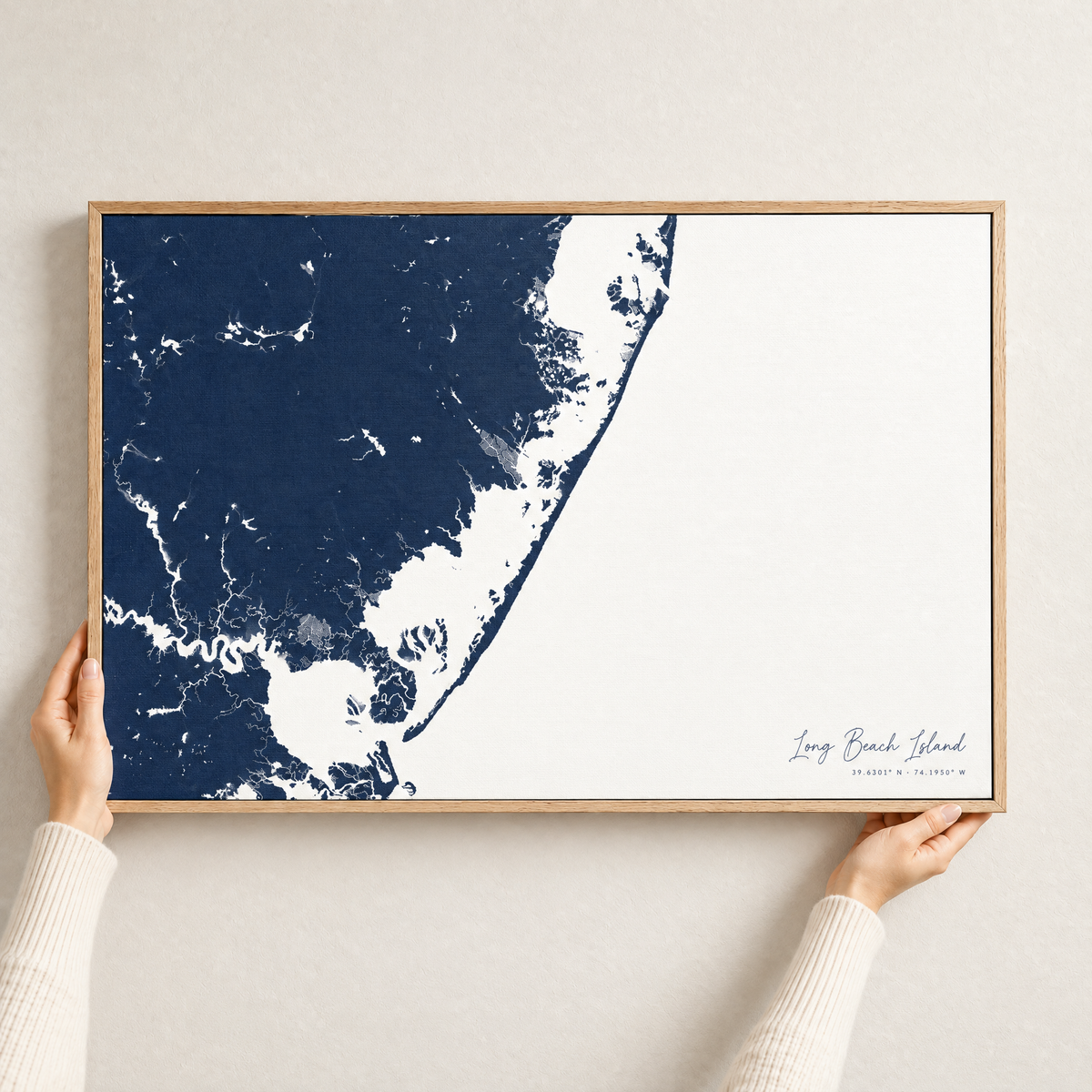 Long Beach Island horizontal canvas map in Navy, hands holding an oak-framed canvas