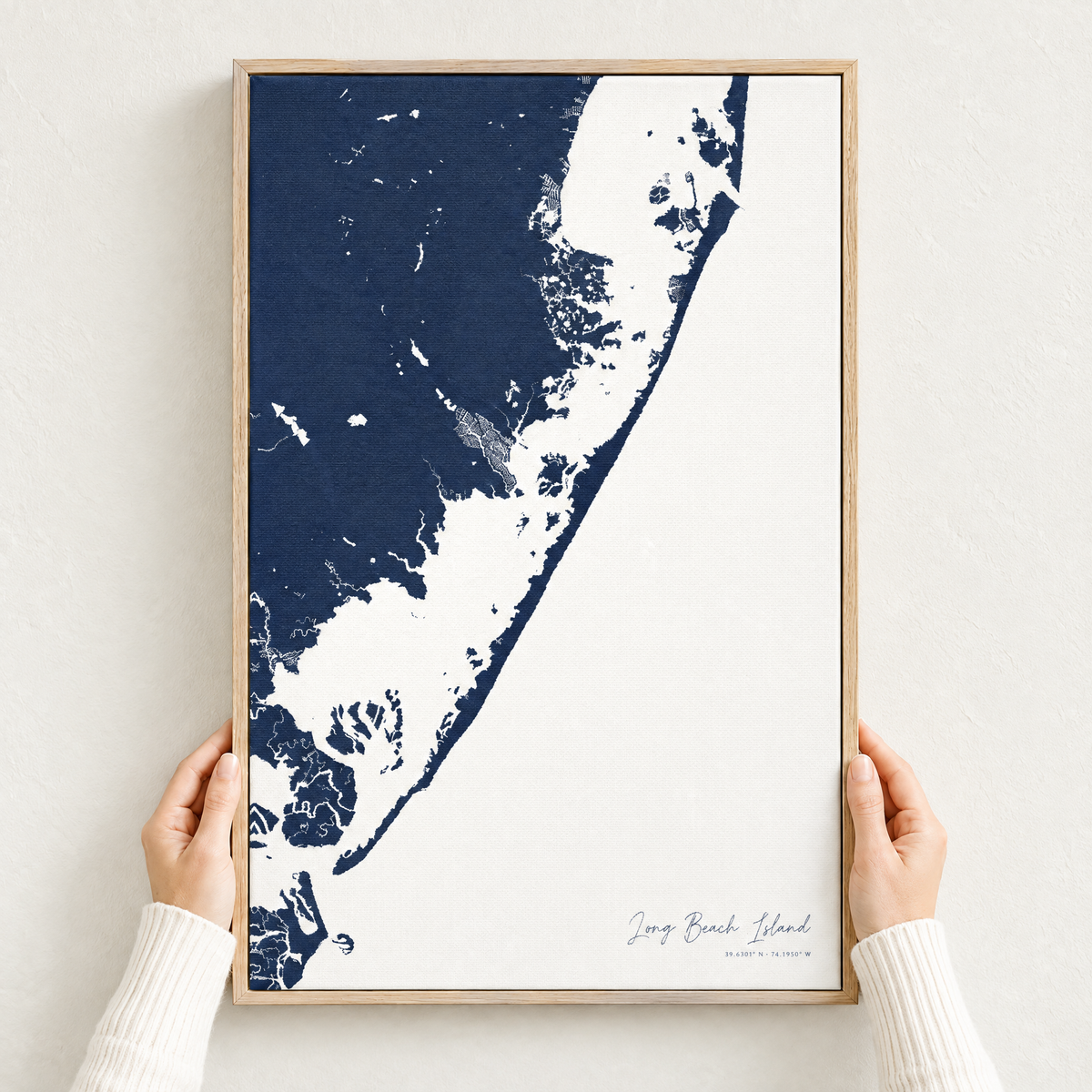 Long Beach Island vertical canvas map in Navy, hands holding an oak-framed canvas